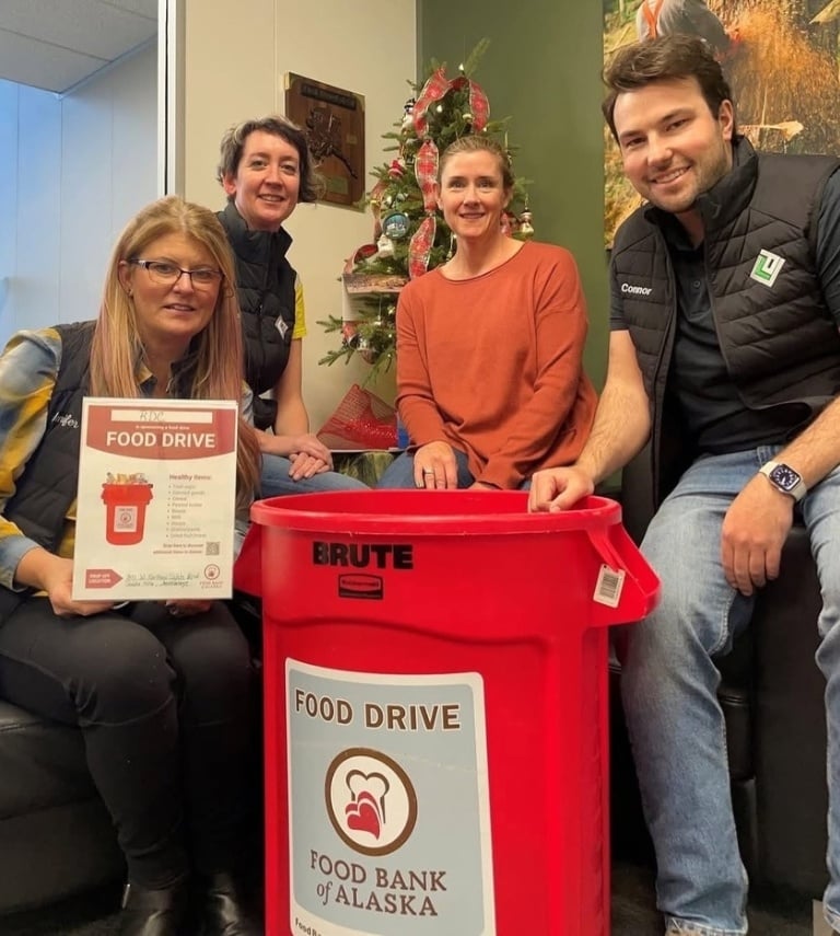 Employees at RDC with their red barrel and food drive sign
